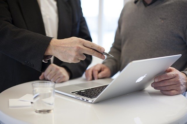 Beratungsgespräch zwischen zwei Personen vor einem Laptop